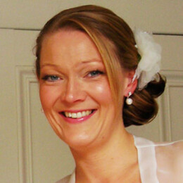 A low side ponytail dresses with a floral chiffon clip. Bridal image